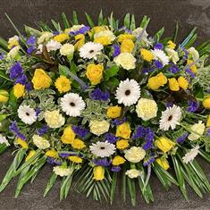 Yellow, purple and white casket spray 